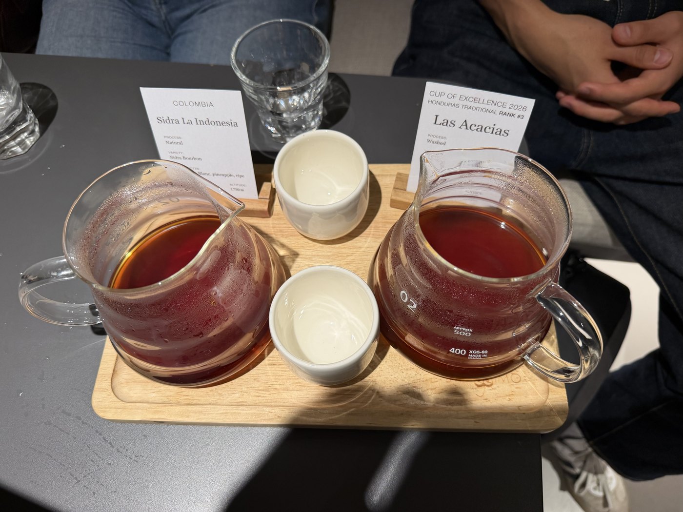 Two glass coffee servers and tasting cups on a tray