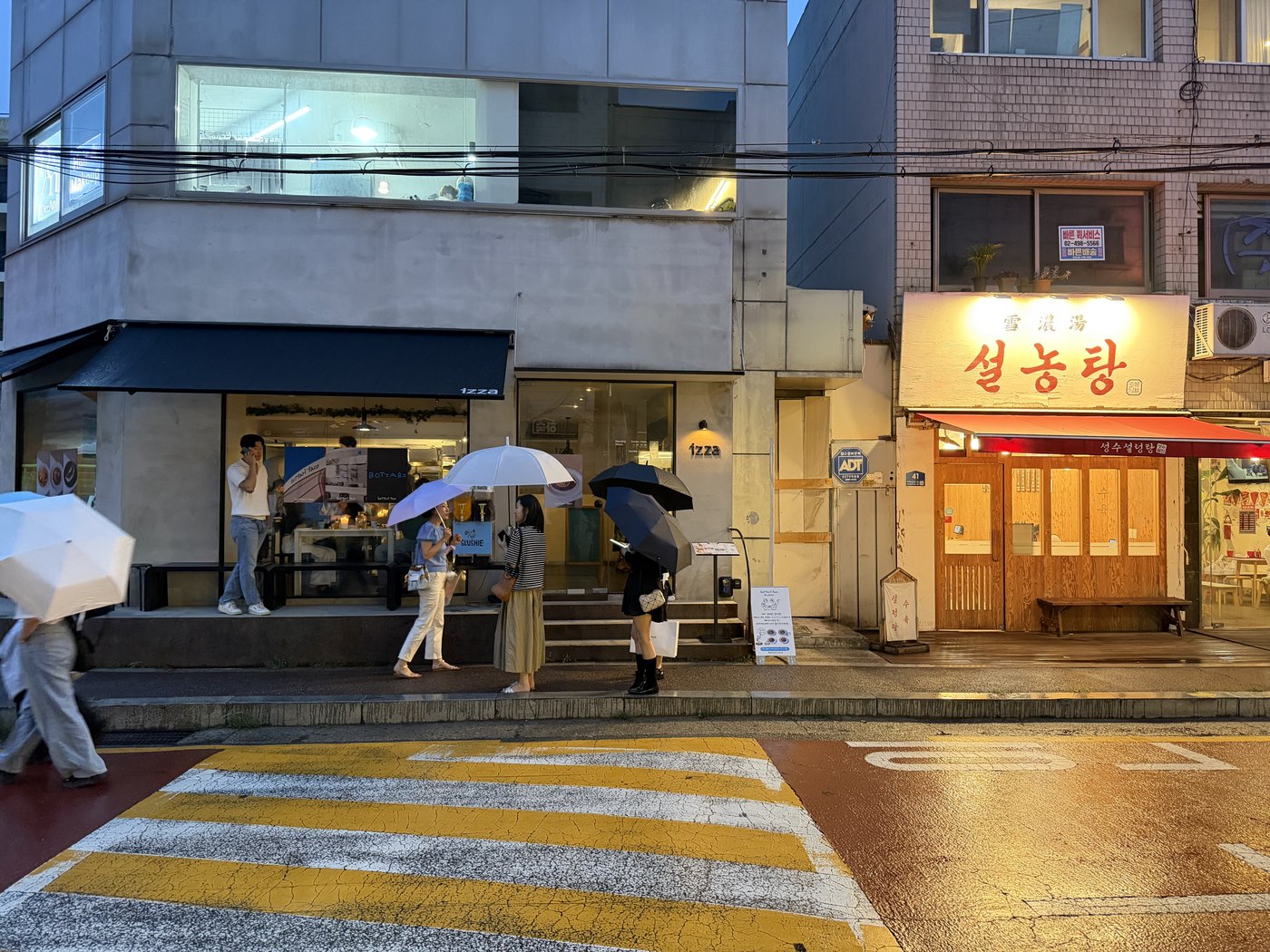 A rainy street outside a coffee shop and restaurant